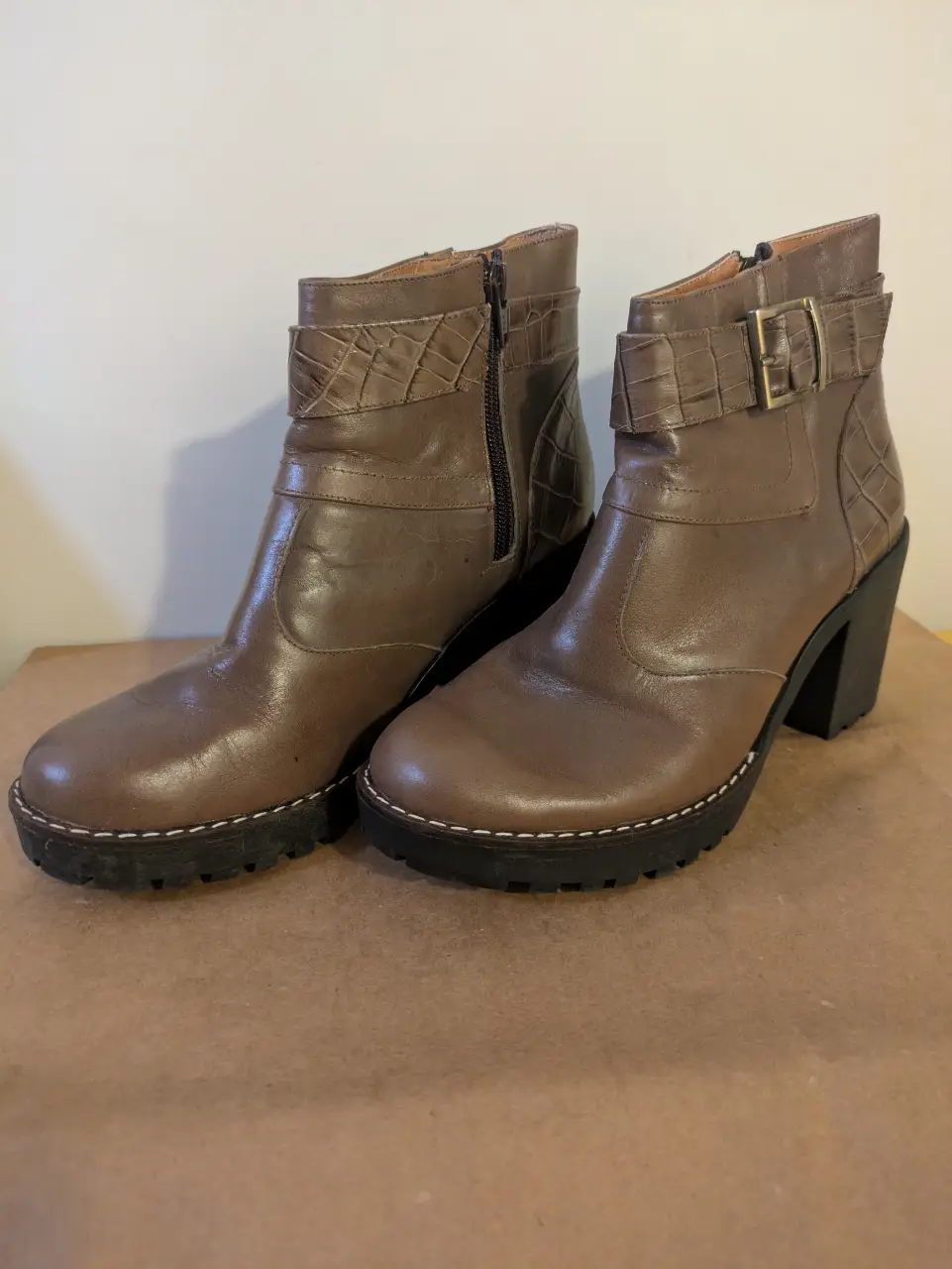 Botines de cuero marrón con detalles de textura de cocodrilo y suela con plataforma. Ideales para un look casual y moderno.