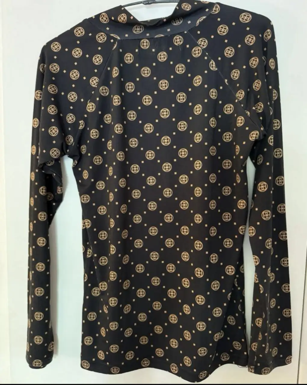 Remera de manga larga Black Mamba, con cuello alto y estampado monograma. Tela elastizada ( polysoft).  Ideal para un look elegante y moderno.