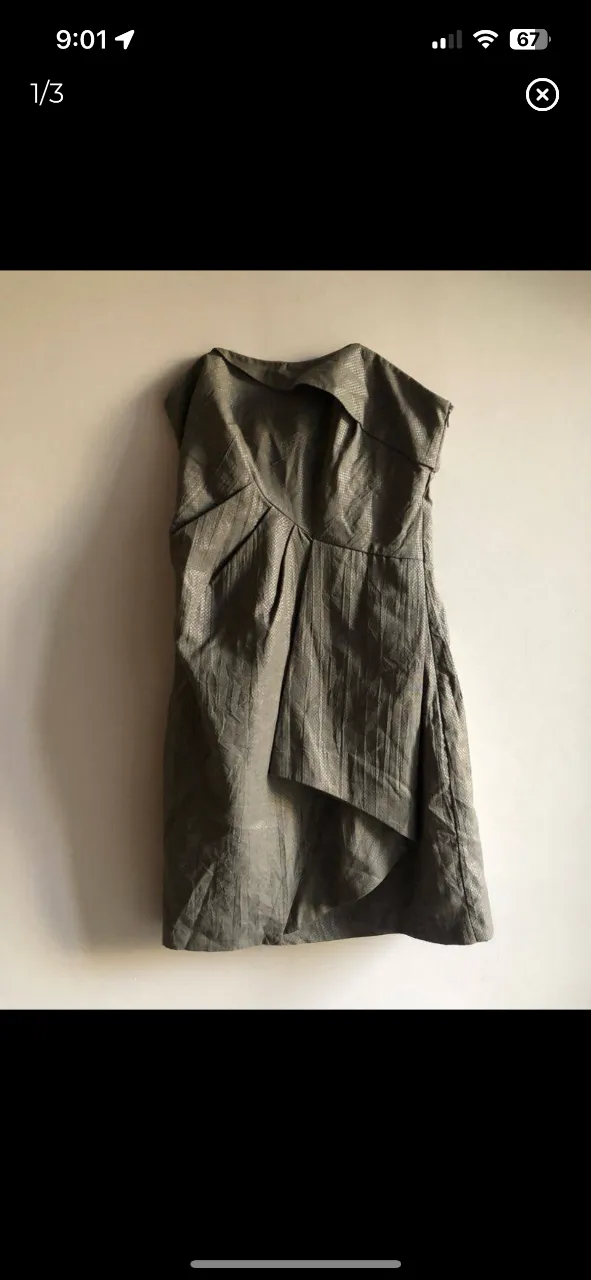 Vestido strapless gris con diseño drapeado y detalle de solapa. Ideal para eventos formales o fiestas.