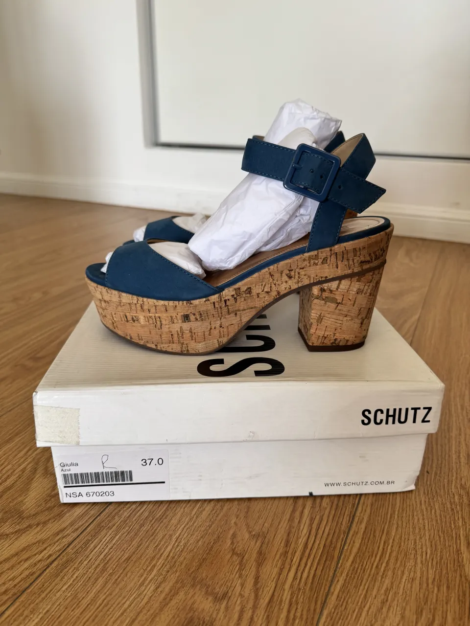 Sandalias de plataforma con taco de corcho y tiras de gamuza azul. Cierre con hebilla en el tobillo. ¡Perfectas para un look veraniego y chic!