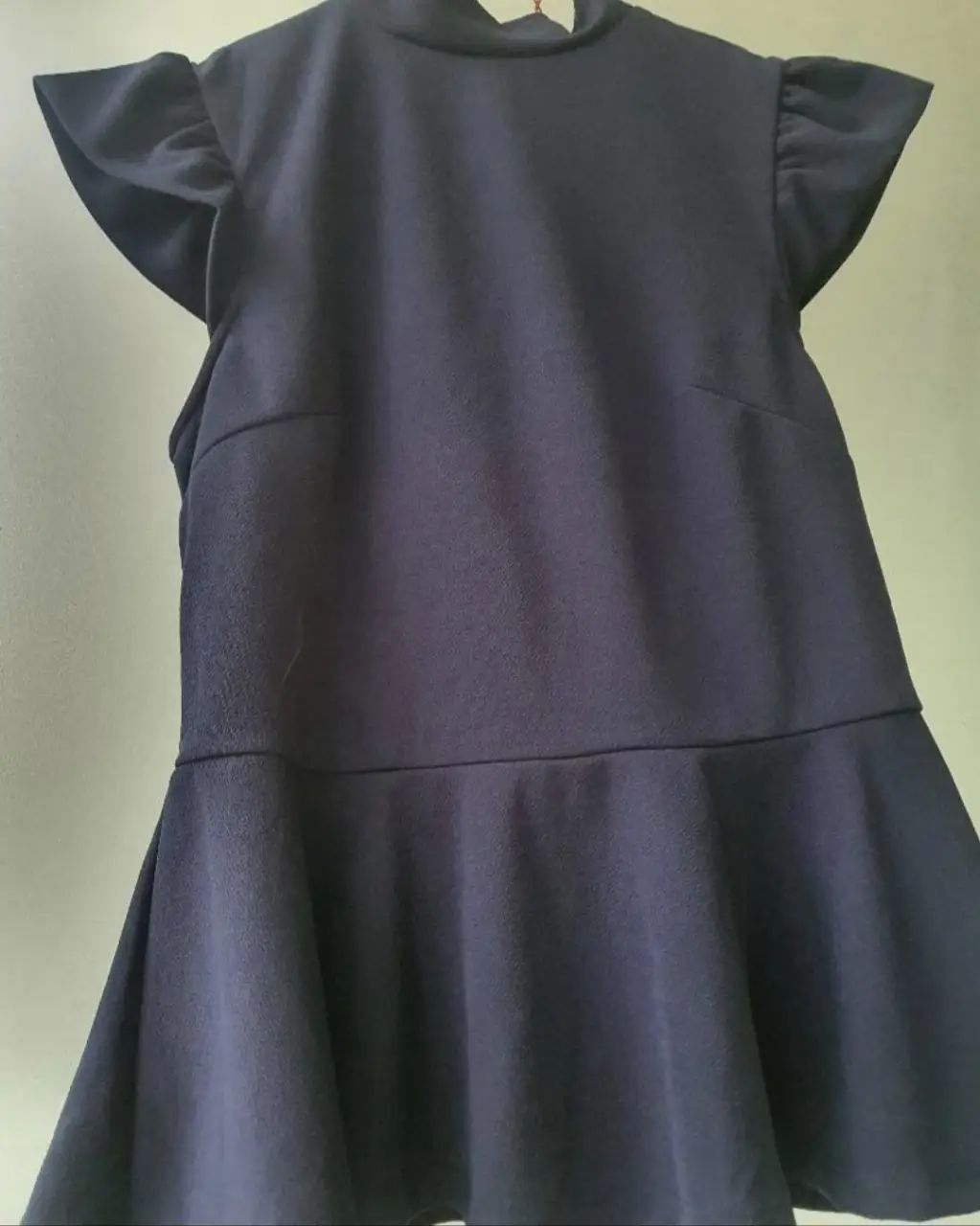 Blusa azul oscura de Markova, con cuello alto y mangas cortas con volados. Ideal para un look elegante y sofisticado.