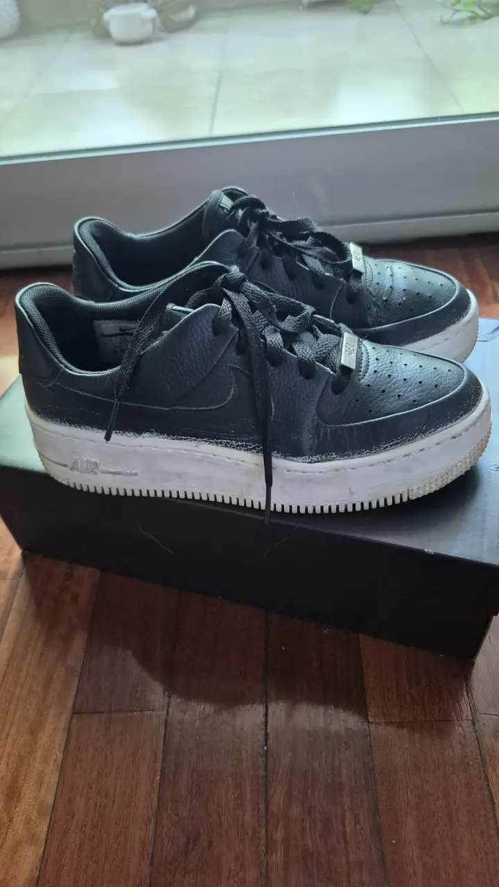 Zapatillas Nike Air Force 1 Sage Low negras con suela blanca. Tienen detalles perforados y el logo de la marca en la lengüeta y el lateral. Ideales para un look casual y moderno.