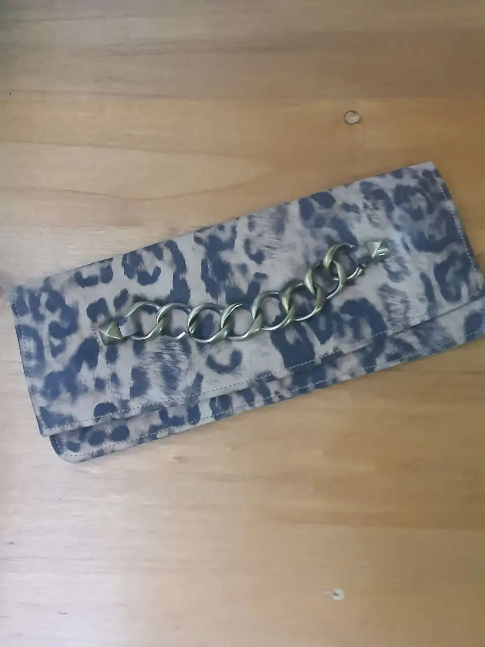 Cartera sobre Besha con estampado de leopardo y cadena dorada. Ideal para un look de fiesta o salida.