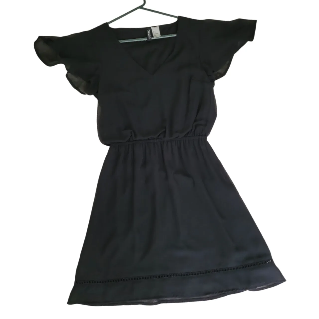 Vestido corto negro con mangas cortas tipo mariposa y cintura elastizada. Ideal para un look elegante y cómodo. Talle S/34.