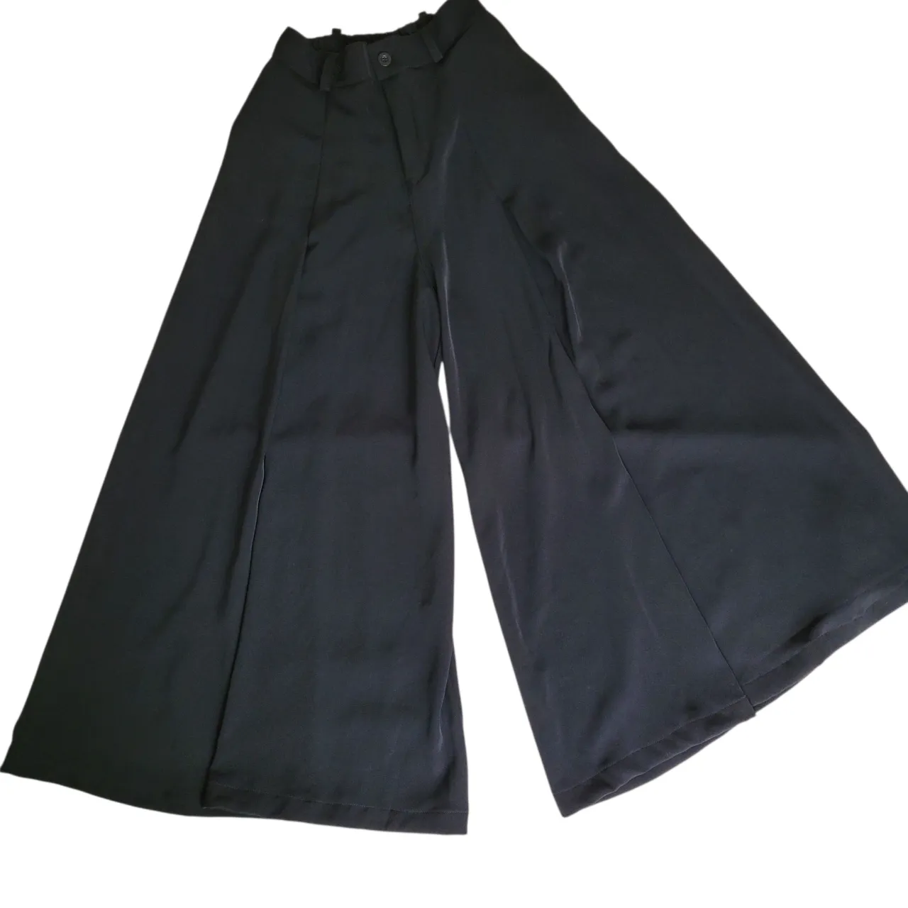 Pantalón sastrero negro de corte muy ancho, tiro bien alto e ideal para un look elegante y moderno. Confeccionado en tela de alta calidad con mucha caida, este pantalón ofrece estilo. Perfecto para combinar con blusas, camisas o tops. Ruedo realizado para persona de 1.60m. Va para talle 36. 