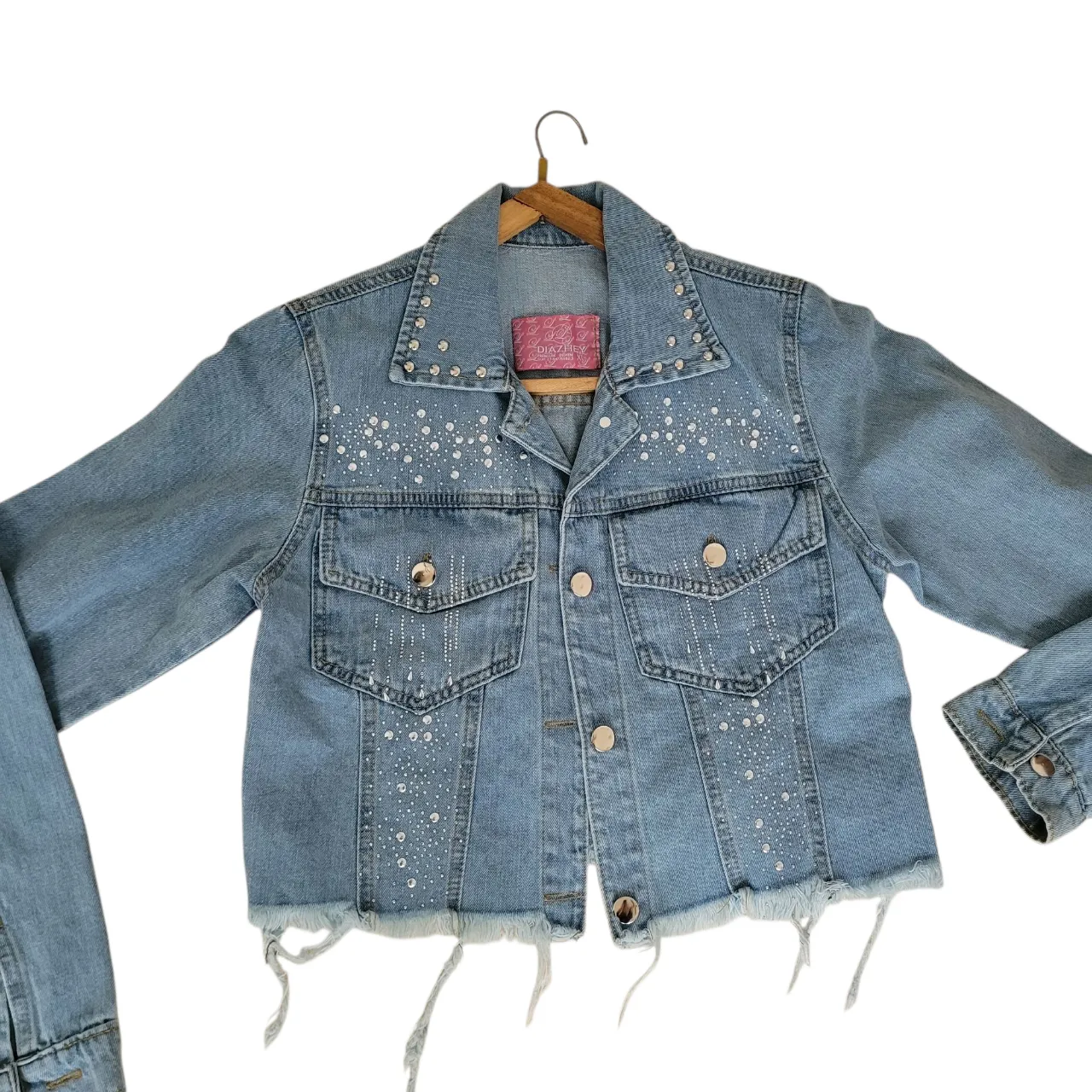 Campera de jean celeste con detalles de strass y flecos en el borde. Corte cropped, ideal para un look canchero y moderno. Perfecta para usar en salidas o eventos informales.