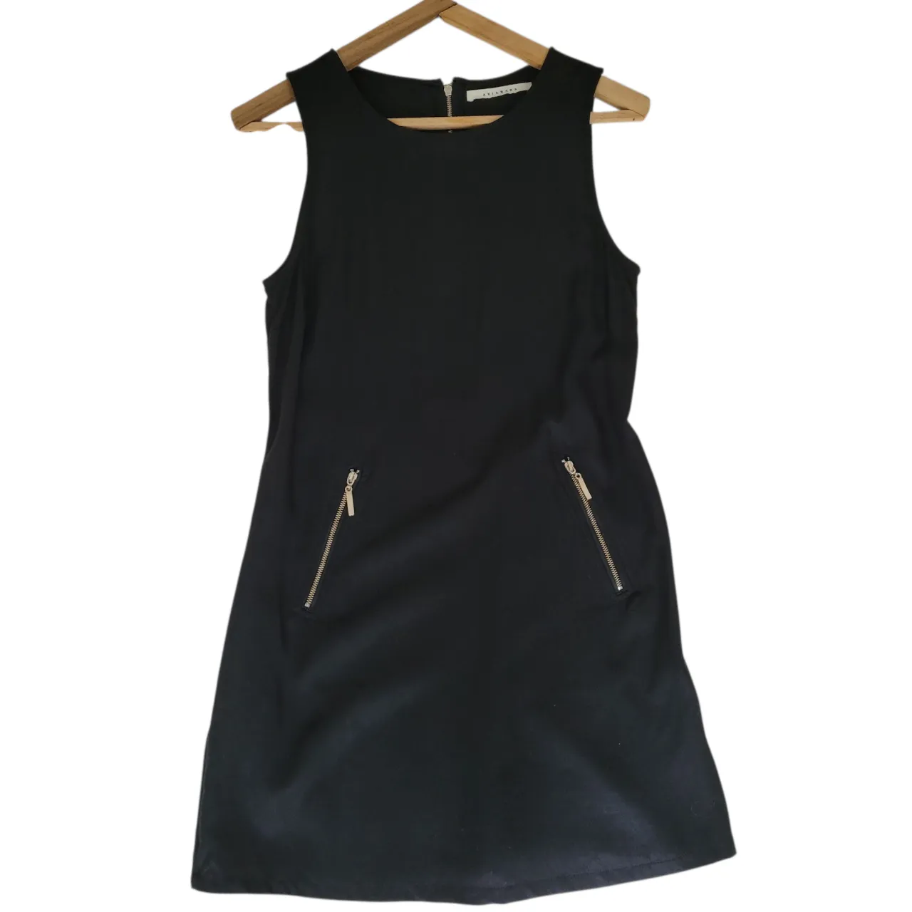 Vestido negro corto, sin mangas, con dos bolsillos con cierre dorado. Ideal para una salida. Talle 2