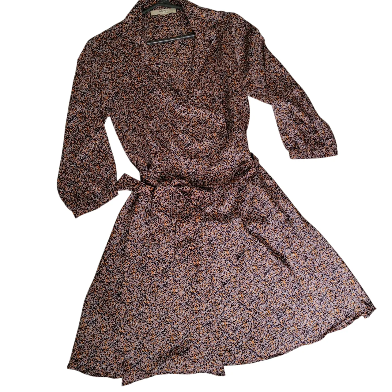 Vestido INDIA STYLE midi con estampado floral miniatura en tonos marrones y detalles en naranja y negro. Diseño envolvente con lazo en la cintura y mangas 3/4. Ideal para un look casual y femenino. Fresco y sedoso.