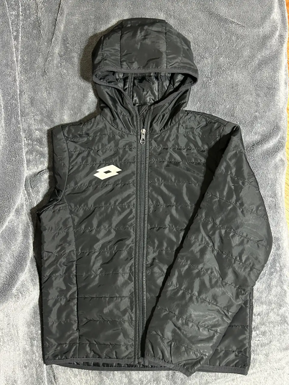 Campera Lotto negra con capucha, prenda unisex.