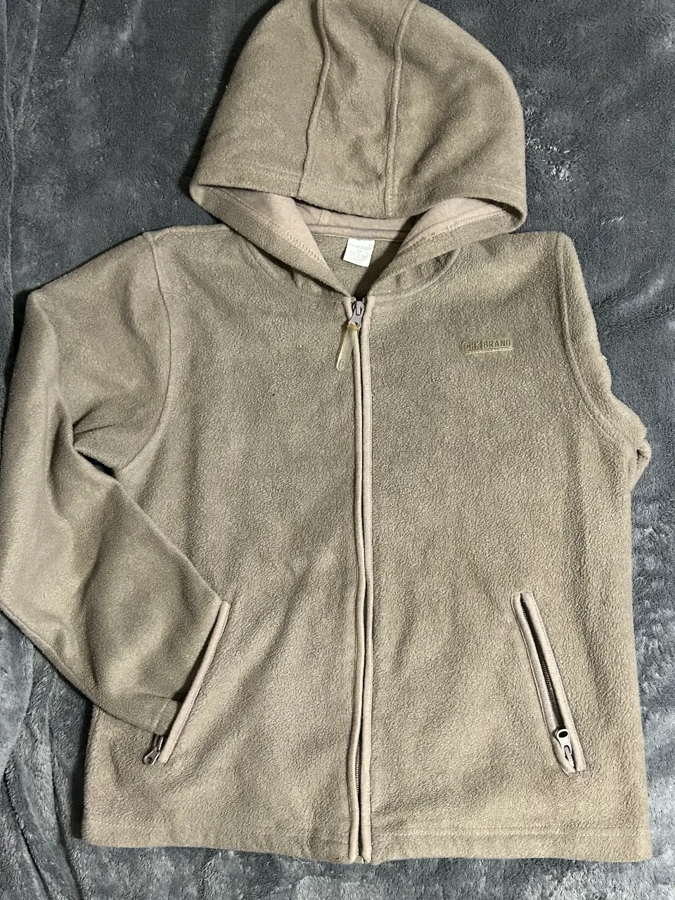 Buzo con cierre de polar, con capucha y bolsillos. Ideal para el invierno, cómodo y abrigado. Perfecto para un look casual y relajado.