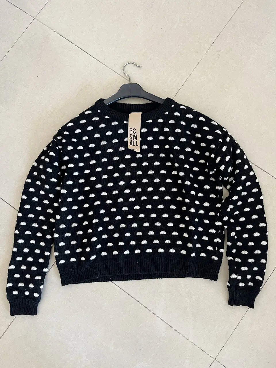 Sweater negro con diseño de lunares blancos. Ideal para un look casual y abrigado.