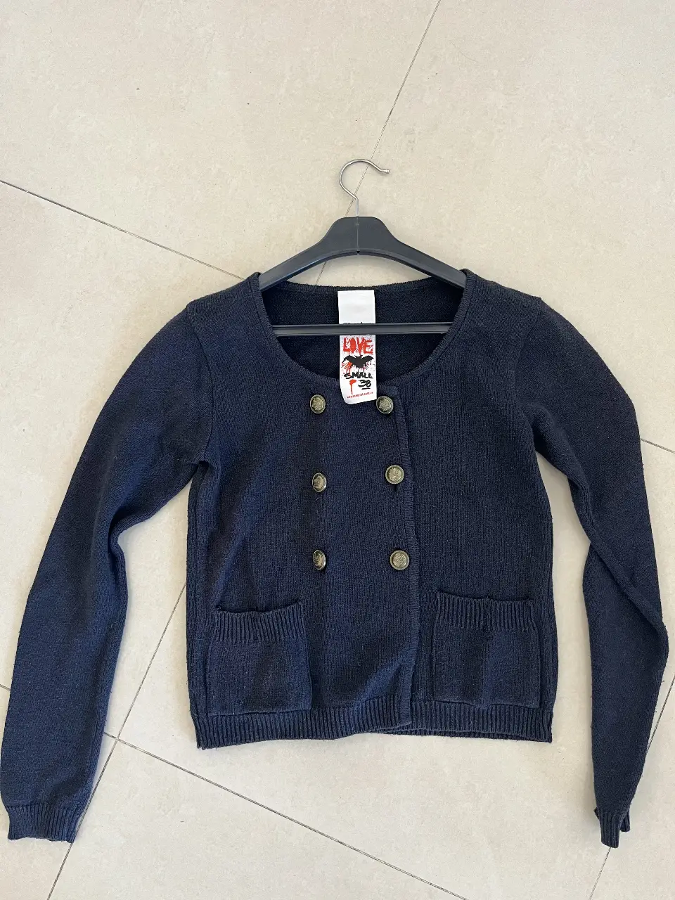 Cardigan de lana azul marino con botones dorados y bolsillos delanteros. Ideal para un look casual y abrigado.