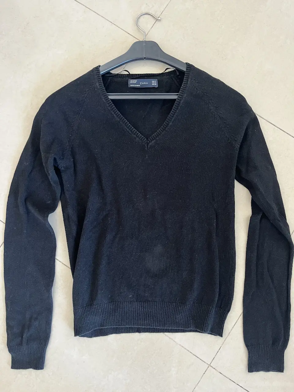 Sweater negro de hombre con cuello en V, de la marca Zara. Ideal para un look casual y versátil.