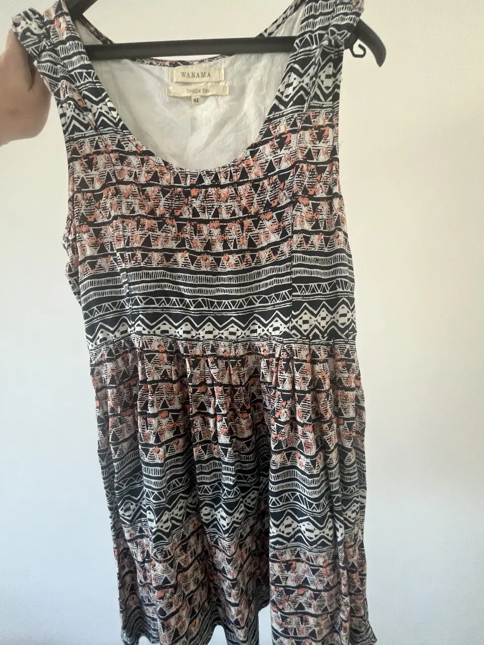 Vestido corto de verano con estampado geométrico en blanco y negro con detalles en naranja. Talle 42, ideal para un look casual y fresco.