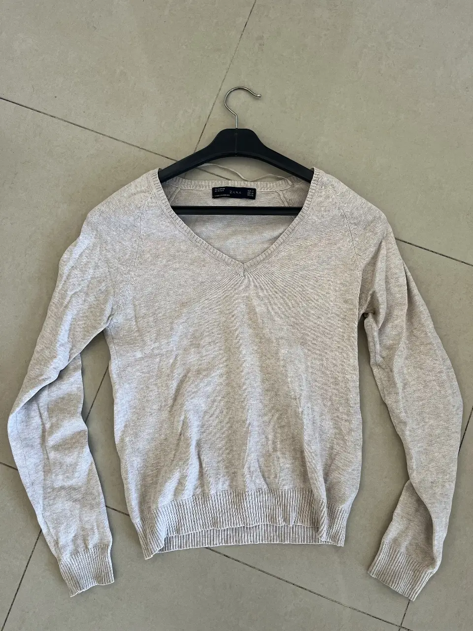 Sweater Zara de mujer, color crudo, con cuello en V y manga larga. Ideal para un look casual y cómodo.