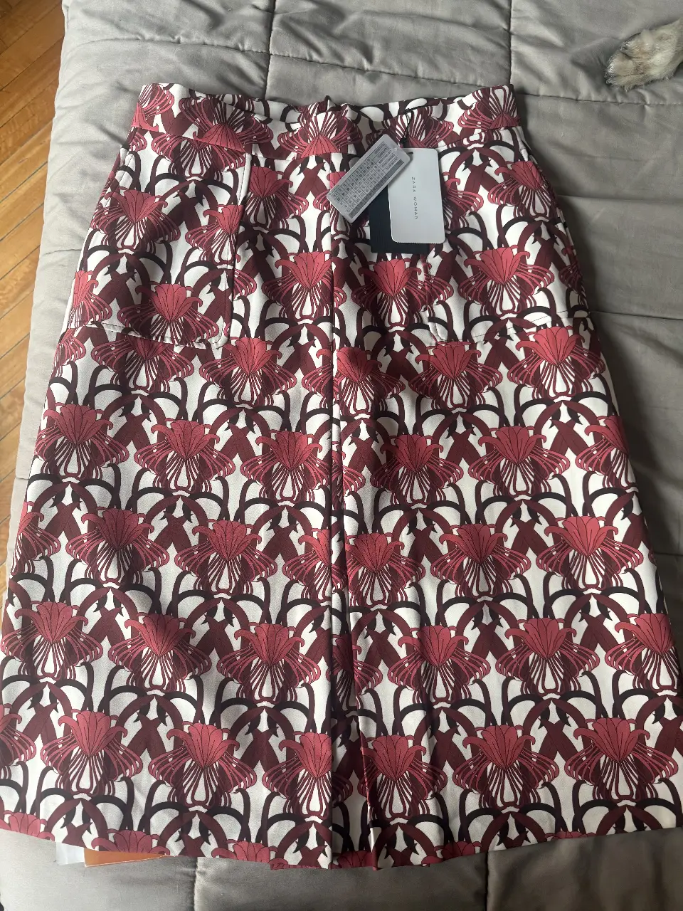 Pollera de mujer con estampado floral en tonos rojos y blancos. Confeccionada en tela de calidad, ideal para un look elegante y sofisticado. Perfecta para combinar con blusas o camisas. Tiene bolsillos 