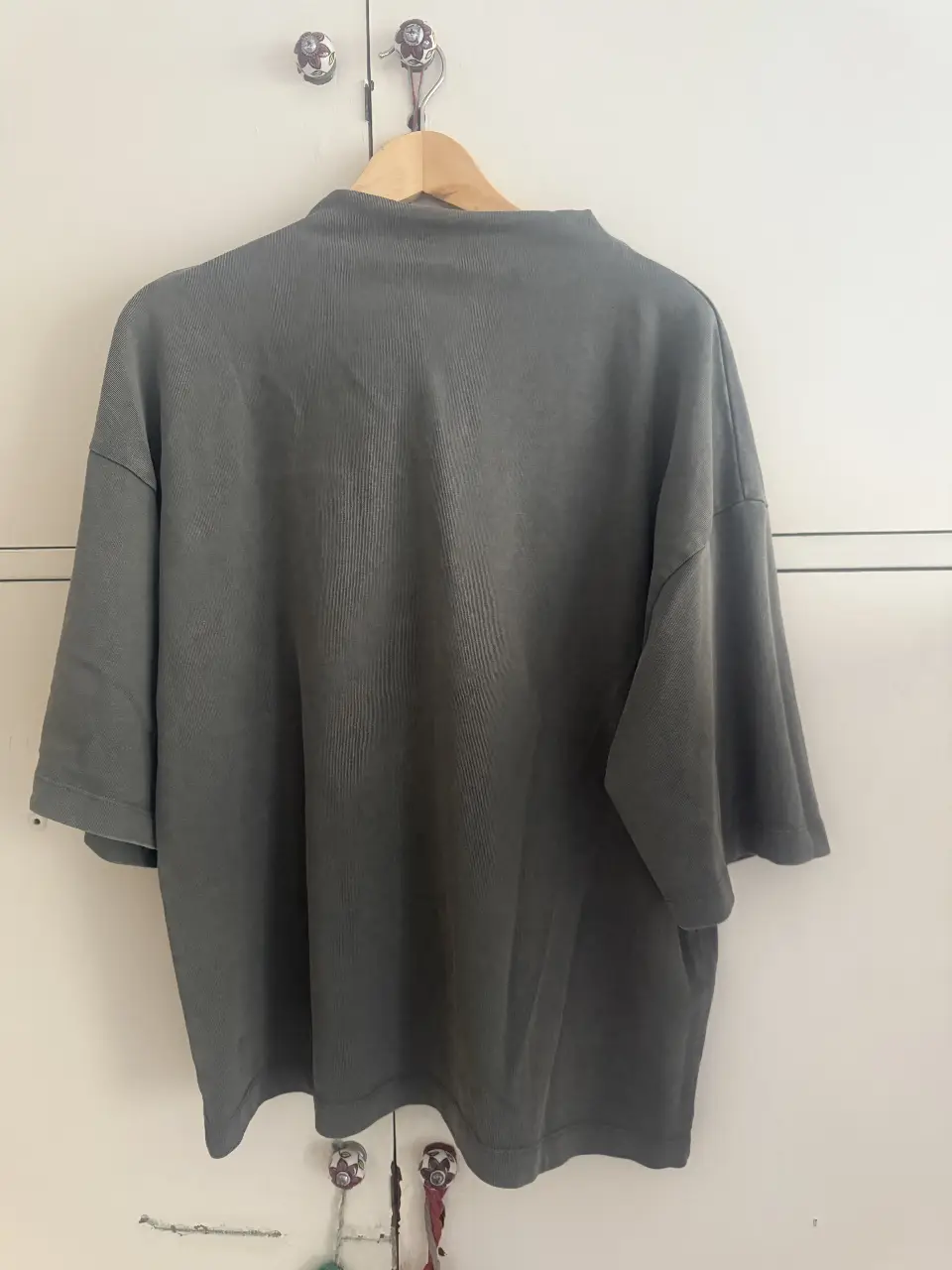 Remera de cuello alto, manga corta, de color gris oscuro, ideal para un look casual y moderno. Confeccionada en un tejido suave y cómodo. oversize tipo buzo