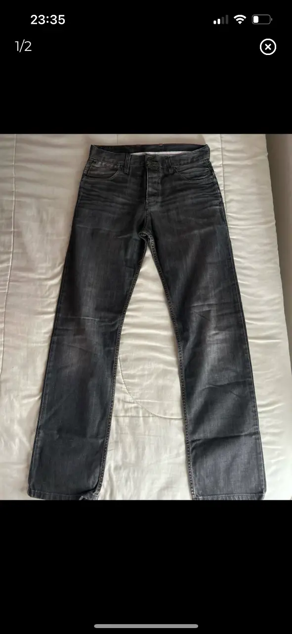 Jeans rectos de hombre, color gris oscuro, con un diseño clásico de cinco bolsillos. Ideal para un look casual y versátil.