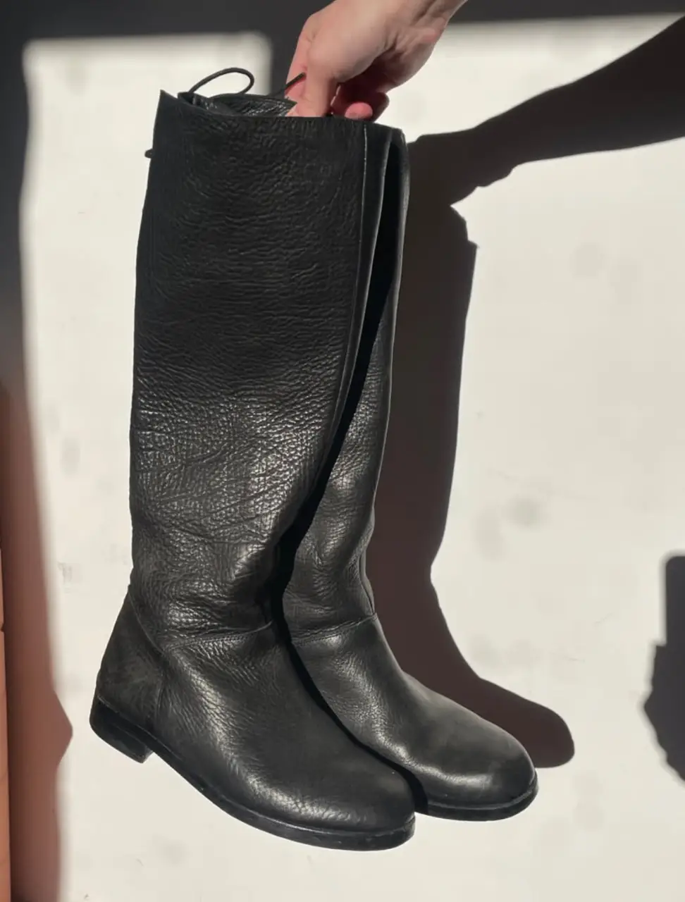 Botas de caña alta de cuero negro, con cierre lateral y cordones en la parte superior. Ideales para un look moderno y sofisticado.