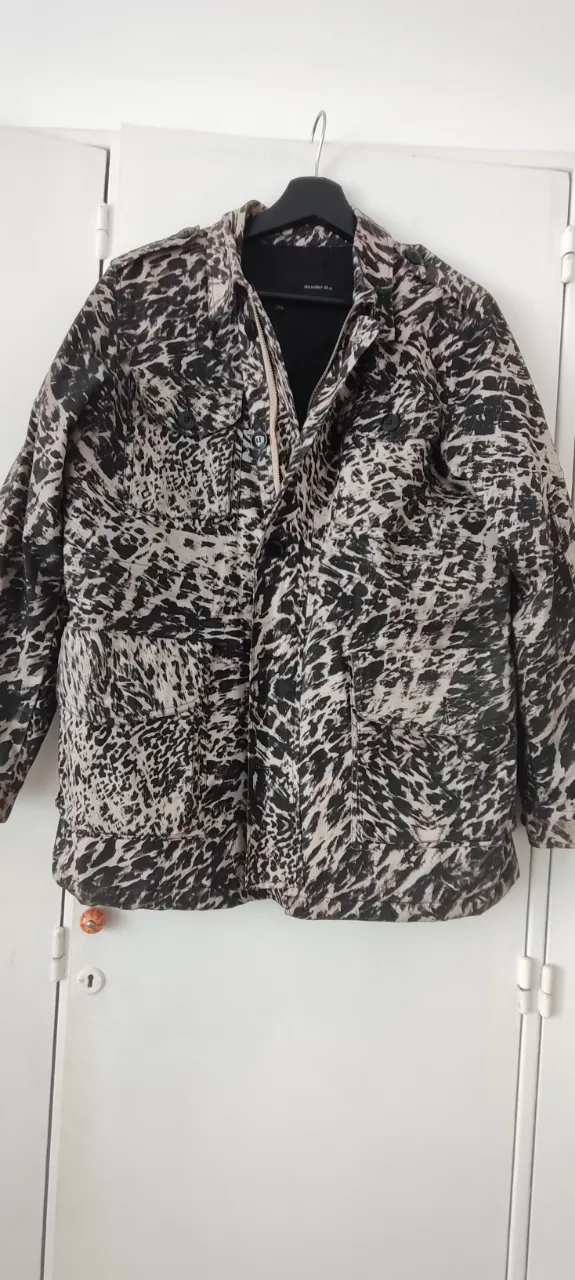 Campera estilo cazadora con un estampado animal print en curso y negro. Posee bolsillos frontales con solapa y cierre. cordones interiores ajustables para entallar. forro matelaado. talle L (46) . marca Desiderata. muy canchera, muchos detalles de confección. Impecable.