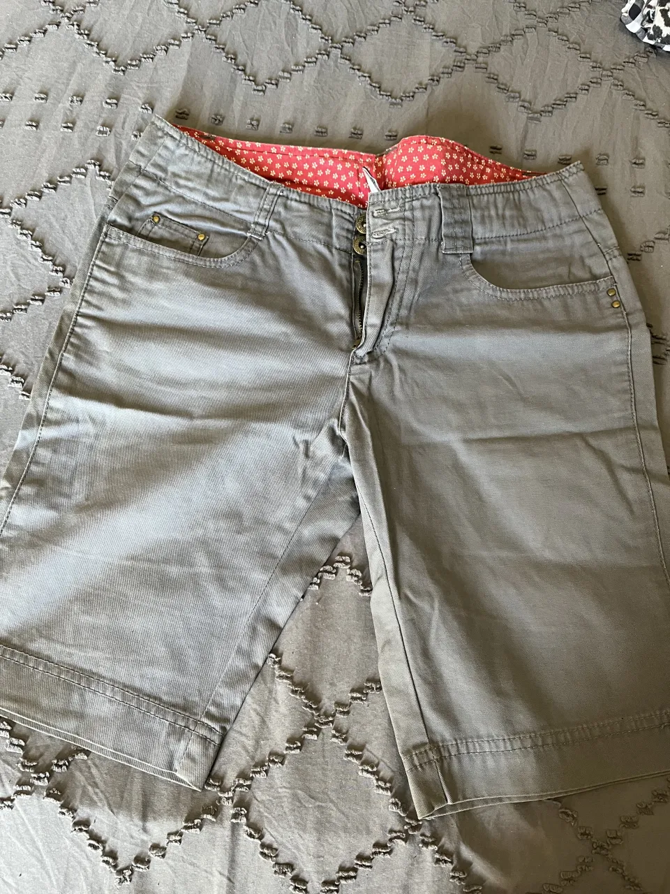 Shorts de gabardina gris con estampado floral en la cintura. Perfectos para un look casual y cómodo.