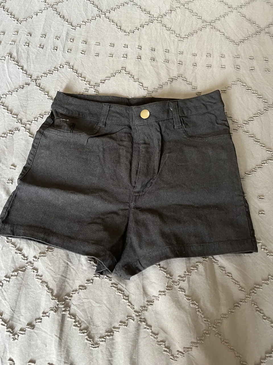 Shorts de gabardina elastizada negros tiro alto, con bolsillos y detalles de costura. Ideales para un look casual y moderno.