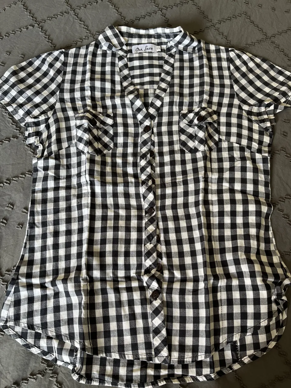 Camisa a cuadros manga corta, ideal para un look casual y fresco. Perfecta para combinar con jeans o shorts.