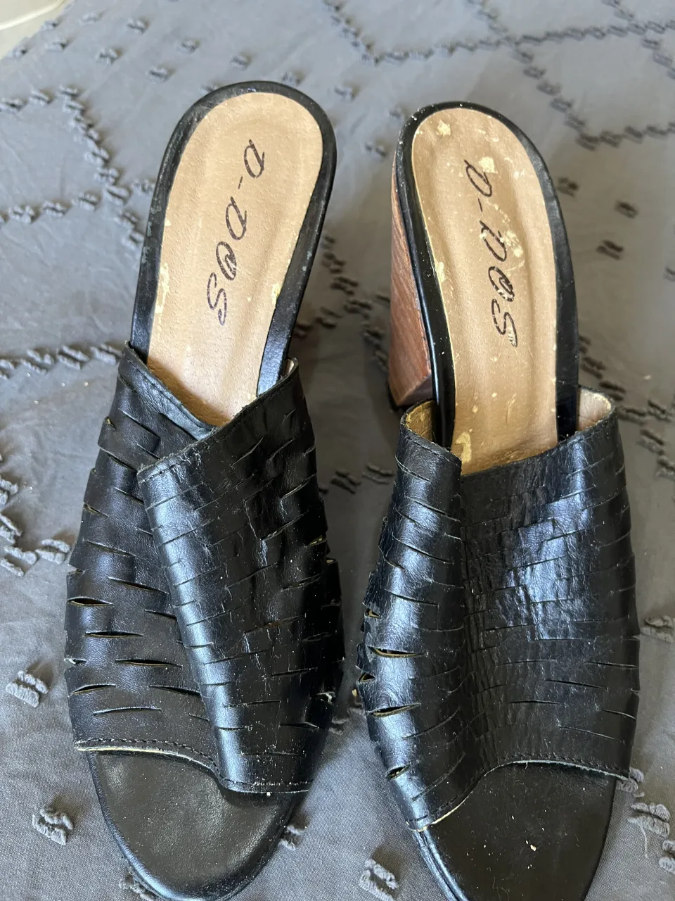 Sandalias de cuero negras con taco de madera. Diseño calado y abierto en la punta. Ideales para un look casual y chic.