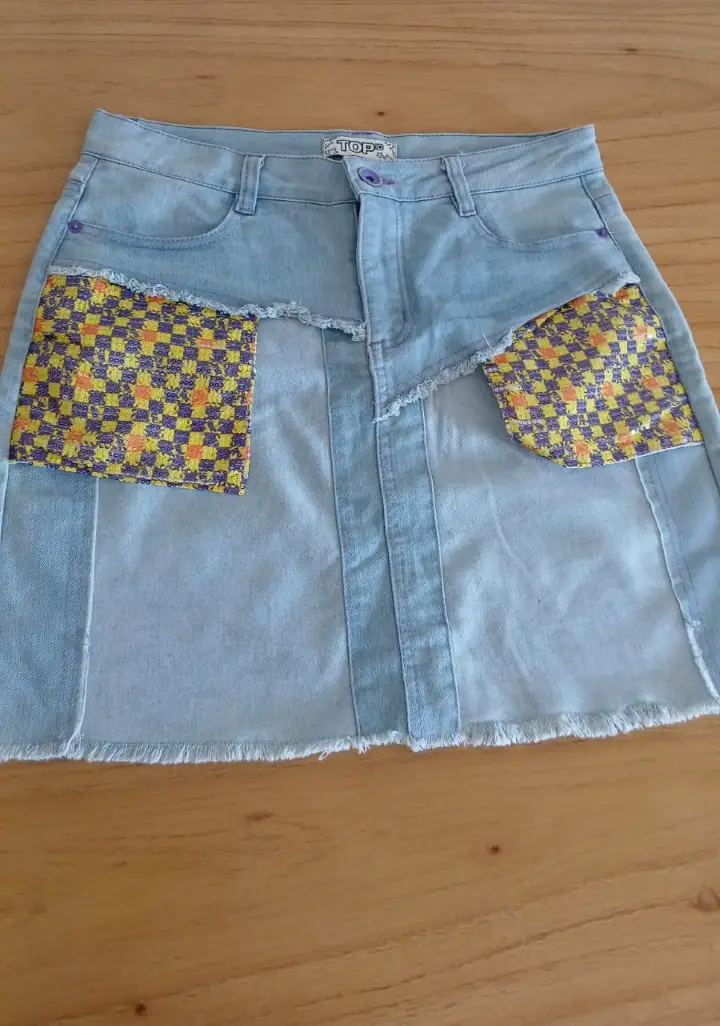 Pollera de jean con detalles de tela estampada en los bolsillos. Diseño único y moderno, ideal para un look casual y con onda.