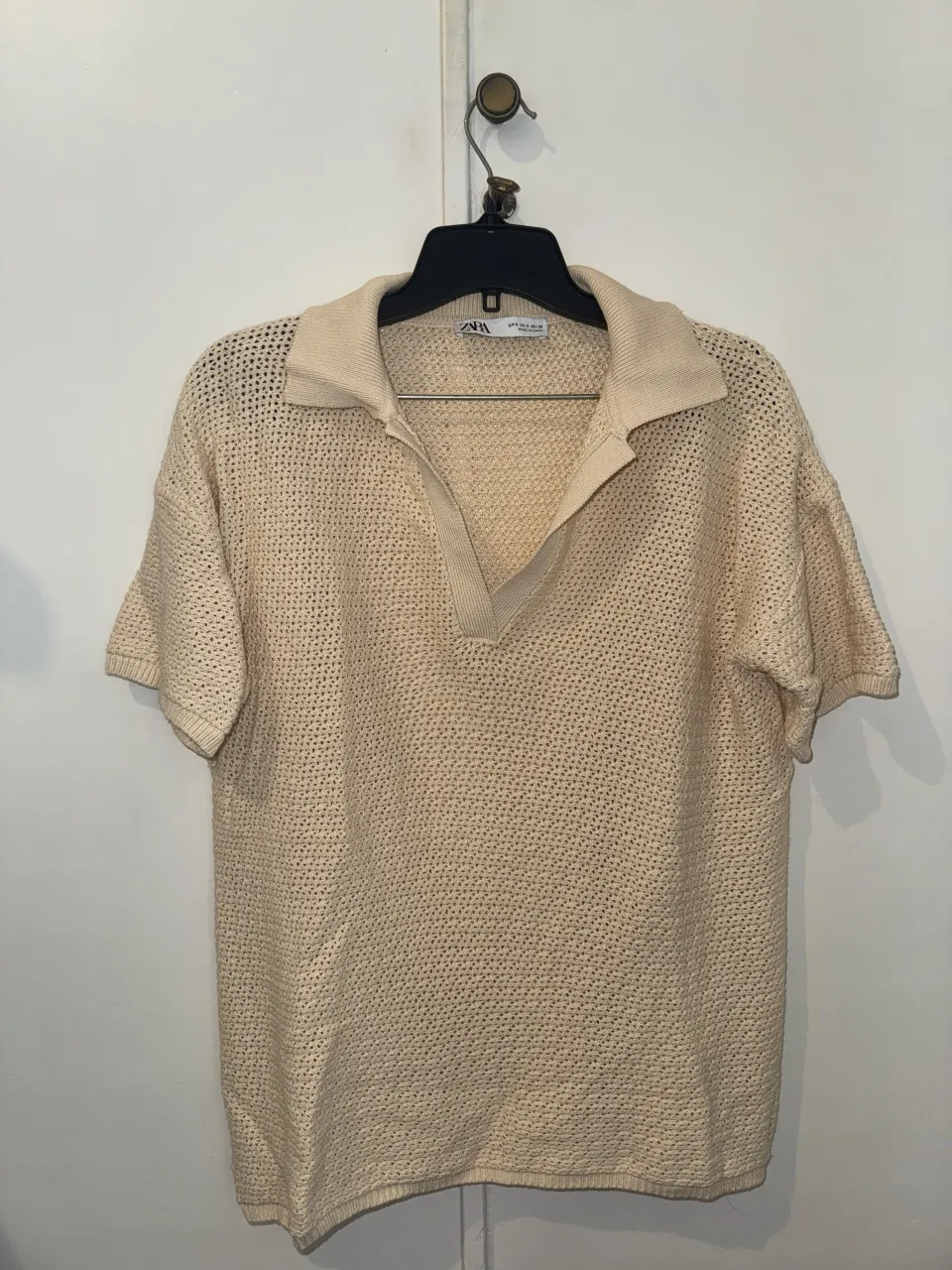 Remera Zara de tejido de punto color crudo con cuello polo y escote en V.
