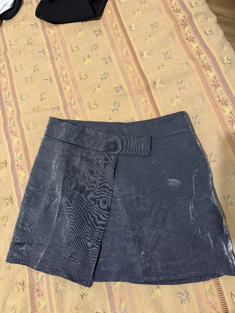 Minifalda gris con diseño asimétrico y detalle de solapa. Ideal para un look moderno y sofisticado.