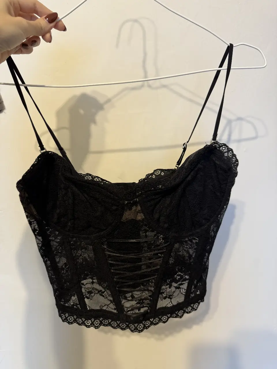 Corpiño tipo corset de encaje negro de la marca CaroCuore. Ideal para darle un toque sensual a tu look. Perfecto para una noche especial o para usar debajo de tu ropa favorita.