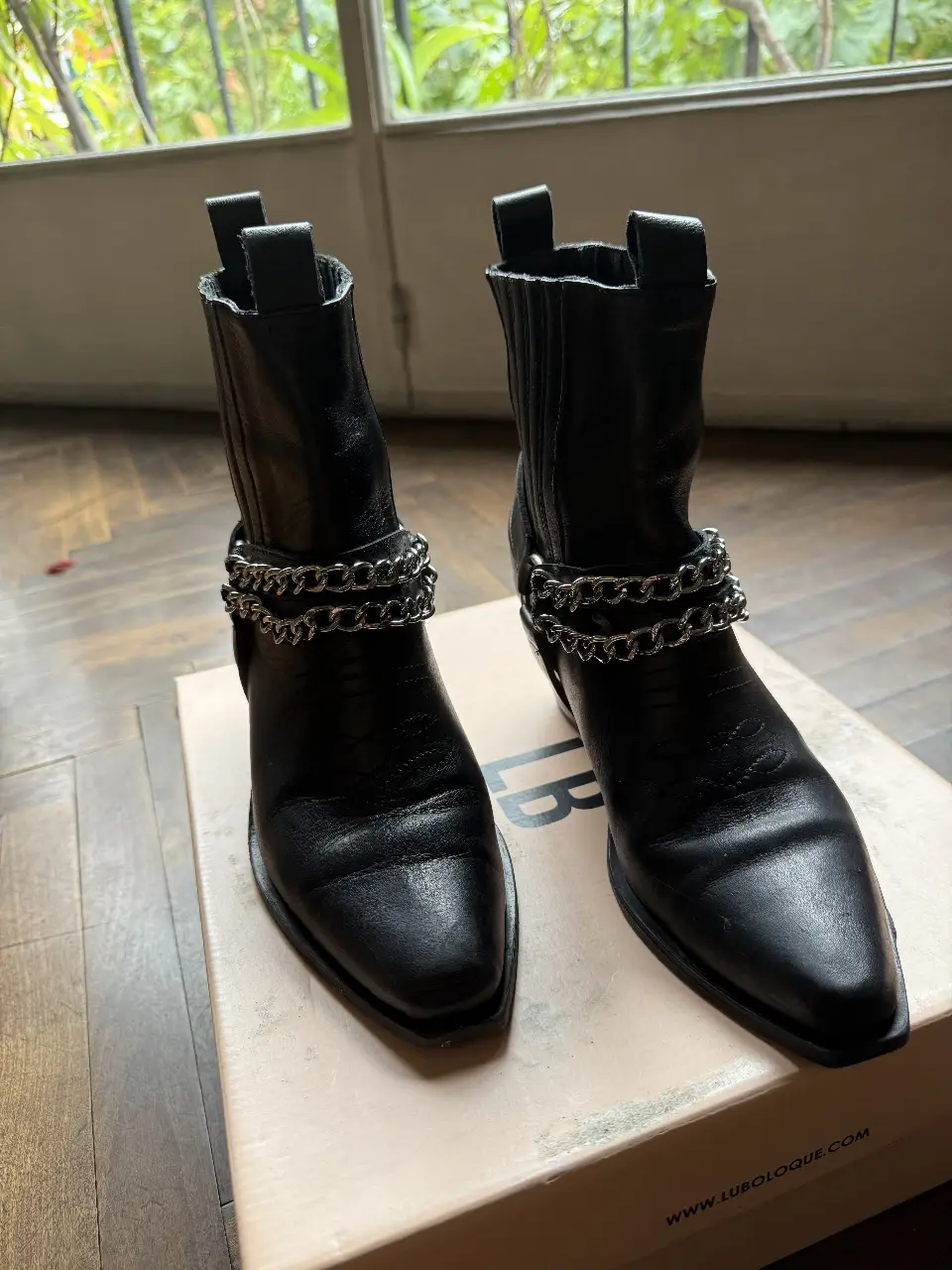 Botines negros de cuero con detalles de cadenas plateadas. Estilo rocker y moderno, ideales para darle un toque canchero a cualquier look. Perfectos para salir o para un estilo casual con onda.