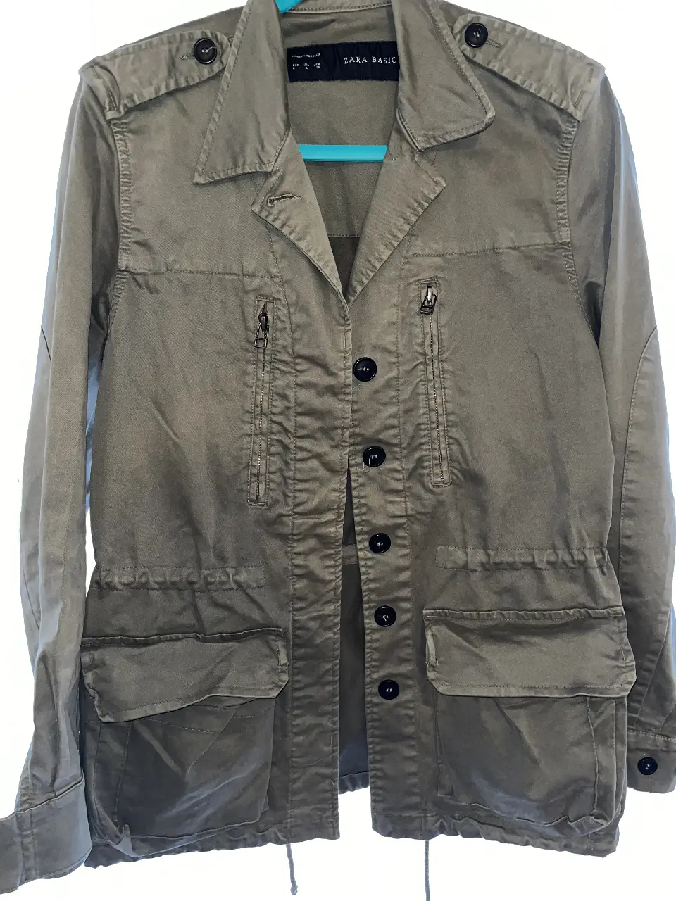 Campera estilo militar de la marca Zara Basic, color verde oliva. Con múltiples bolsillos, botones y cierre. Ideal para un look casual y con estilo.