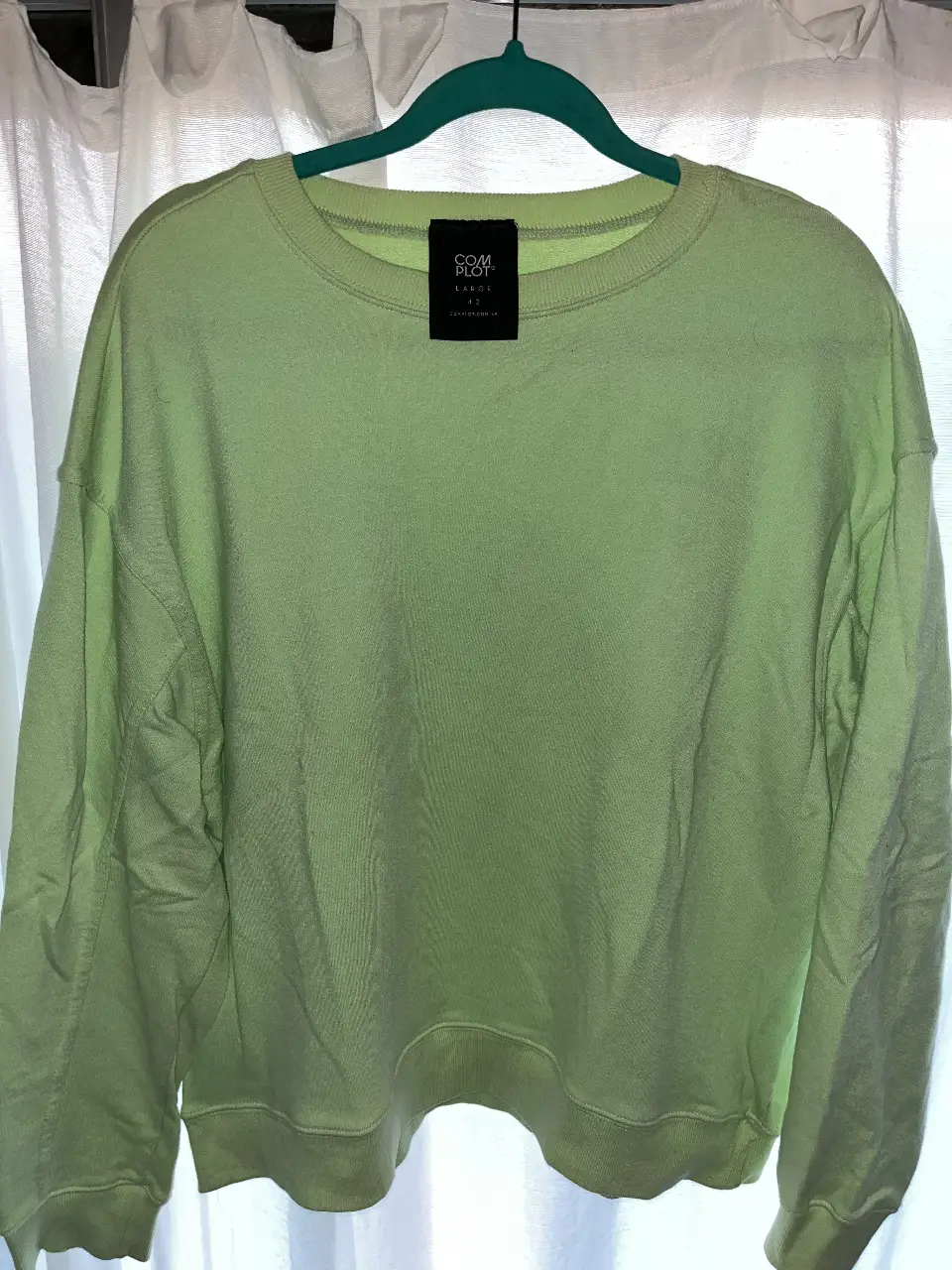Buzo de cuello redondo color verde claro, de la marca COMPLOT. Talle L. Ideal para un look casual y cómodo.