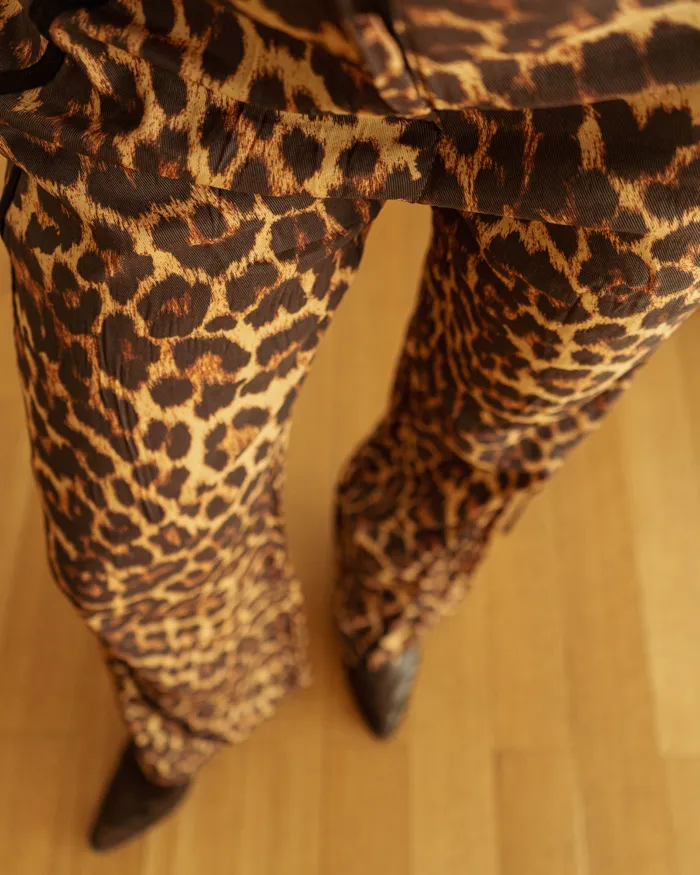 Pantalón sastrero de mujer con estampado de leopardo. Tiro alto, corte recto y detalles de cinta negra en los laterales. Para un look ecléctico.