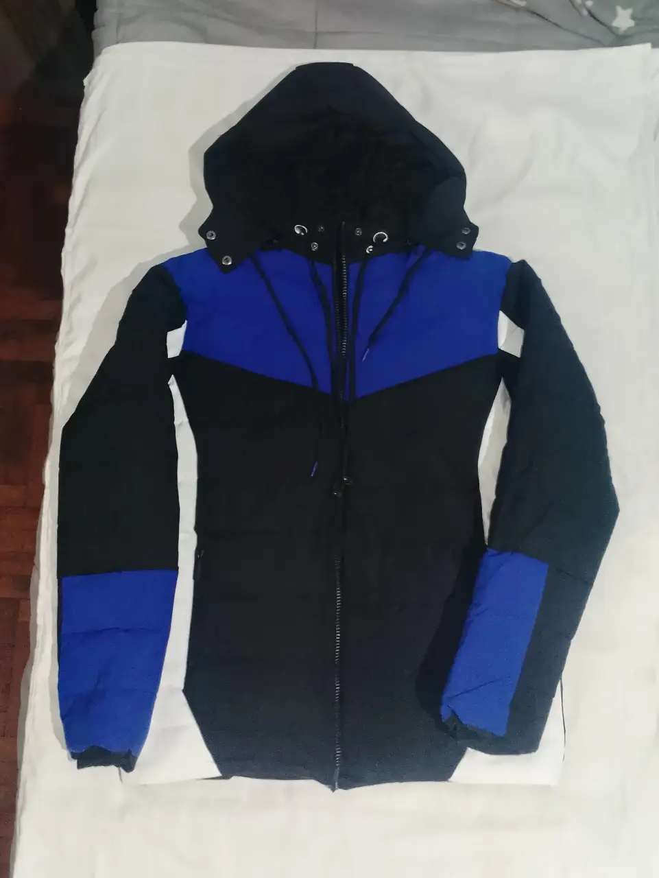 Campera deportiva para hombre, con capucha y cierre. Diseño en color negro y azul. Ideal para el invierno.