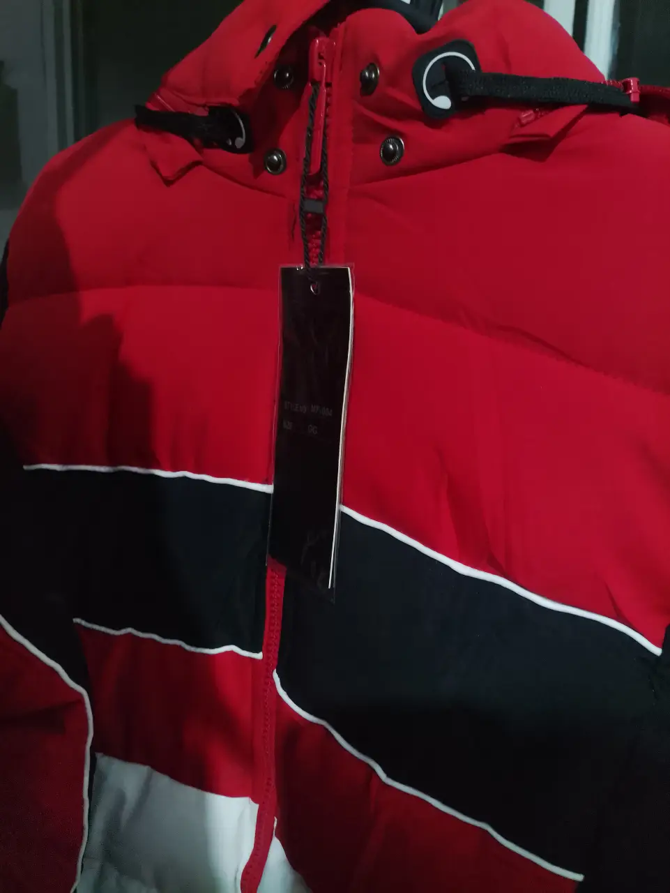 Campera de poliester roja, negro y blanco. Ideal para el invierno, con cierre y capucha. 