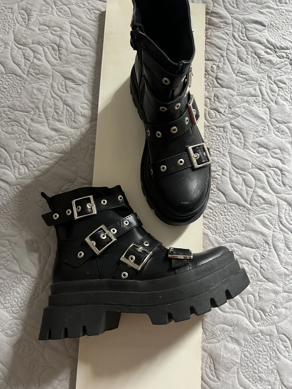 Botas negras con plataforma y múltiples hebillas.