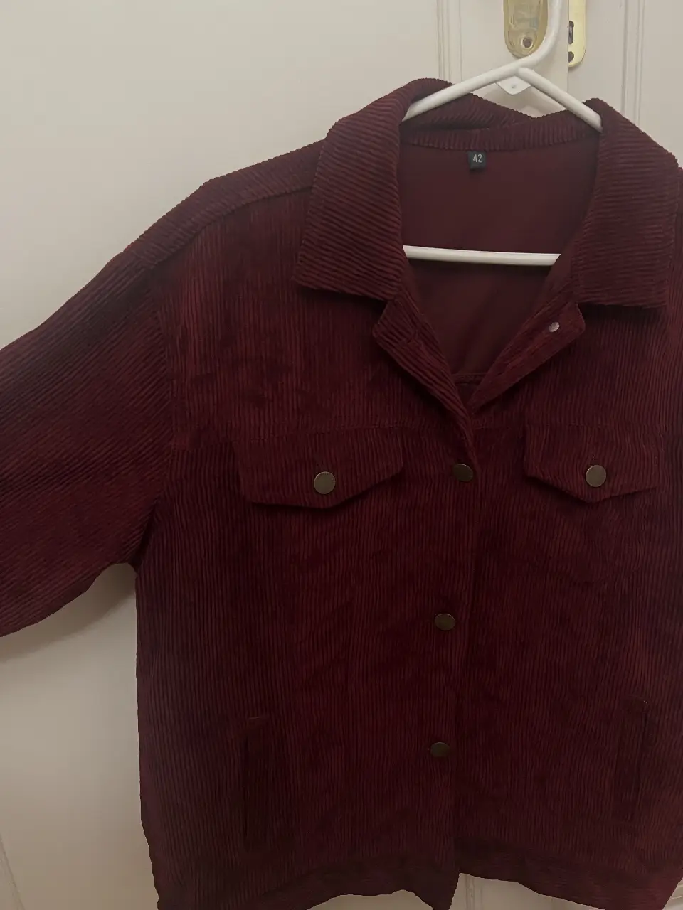 Campera de corderoy color bordo, con botones y bolsillos delanteros. Sin uso
