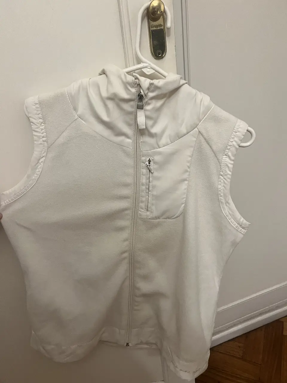 Chaleco blanco con cierre y bolsillo, ideal para actividades deportivas o uso casual. Diseño versátil y cómodo.