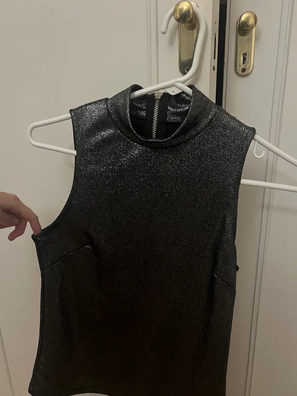 Top de fiesta negro con cuello alto y cierre en la espalda. Ideal para eventos especiales.