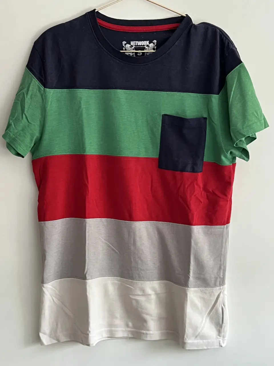 Remera de hombre a rayas horizontales en azul, verde, rojo, gris y blanco. Con bolsillo en el pecho. Ideal para un look casual y moderno.