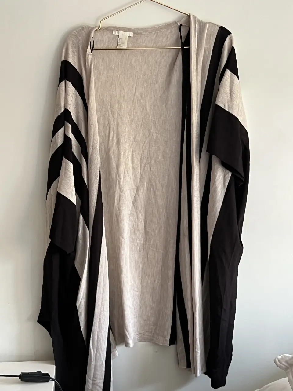 Cárdigan de mujer con diseño a rayas en color crudo y negro. Ideal para un look casual y cómodo.