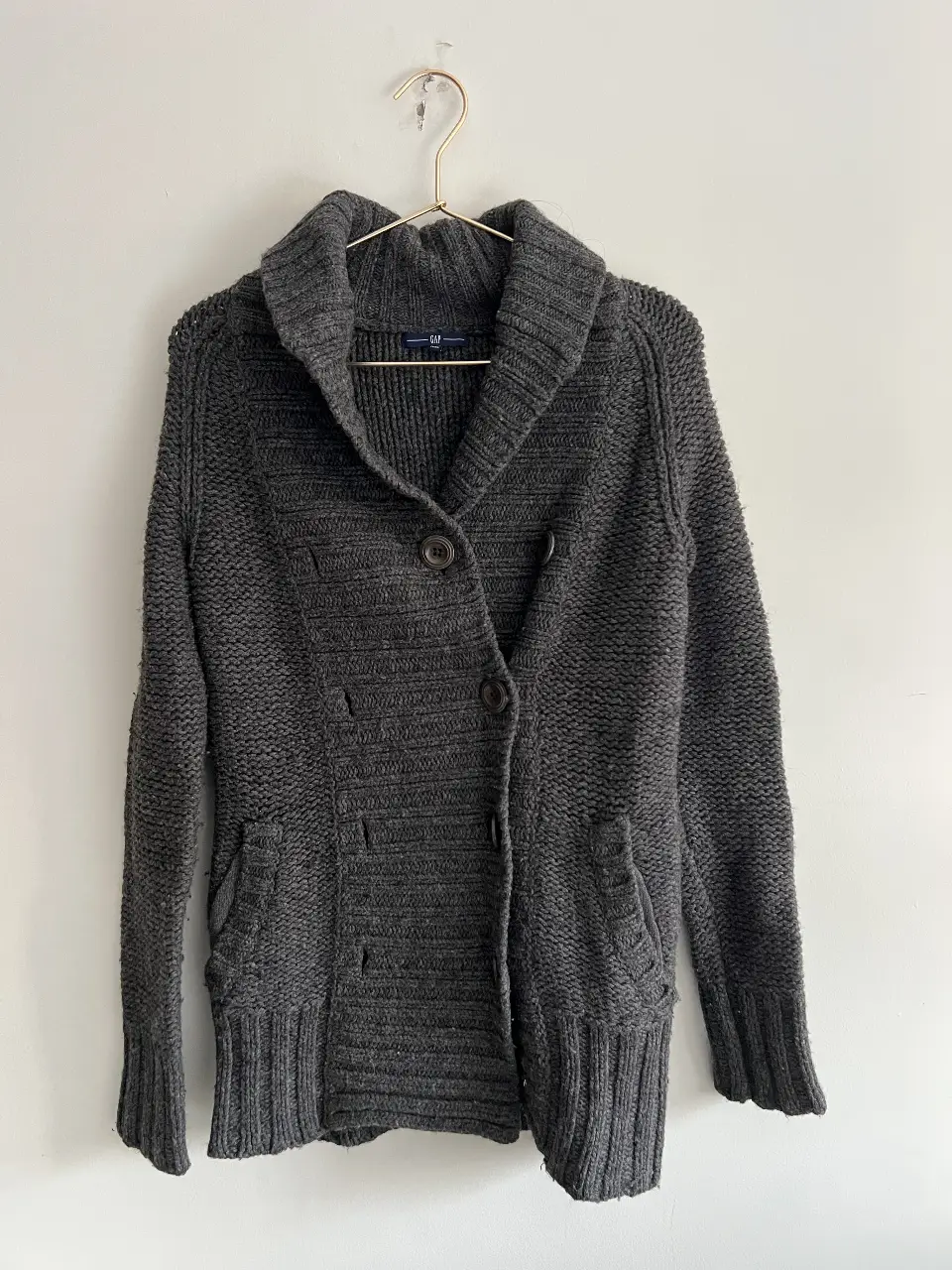 Cardigan de mujer de punto grueso en color gris oscuro, con cuello solapa y cierre con botones. Ideal para un look casual y abrigado.