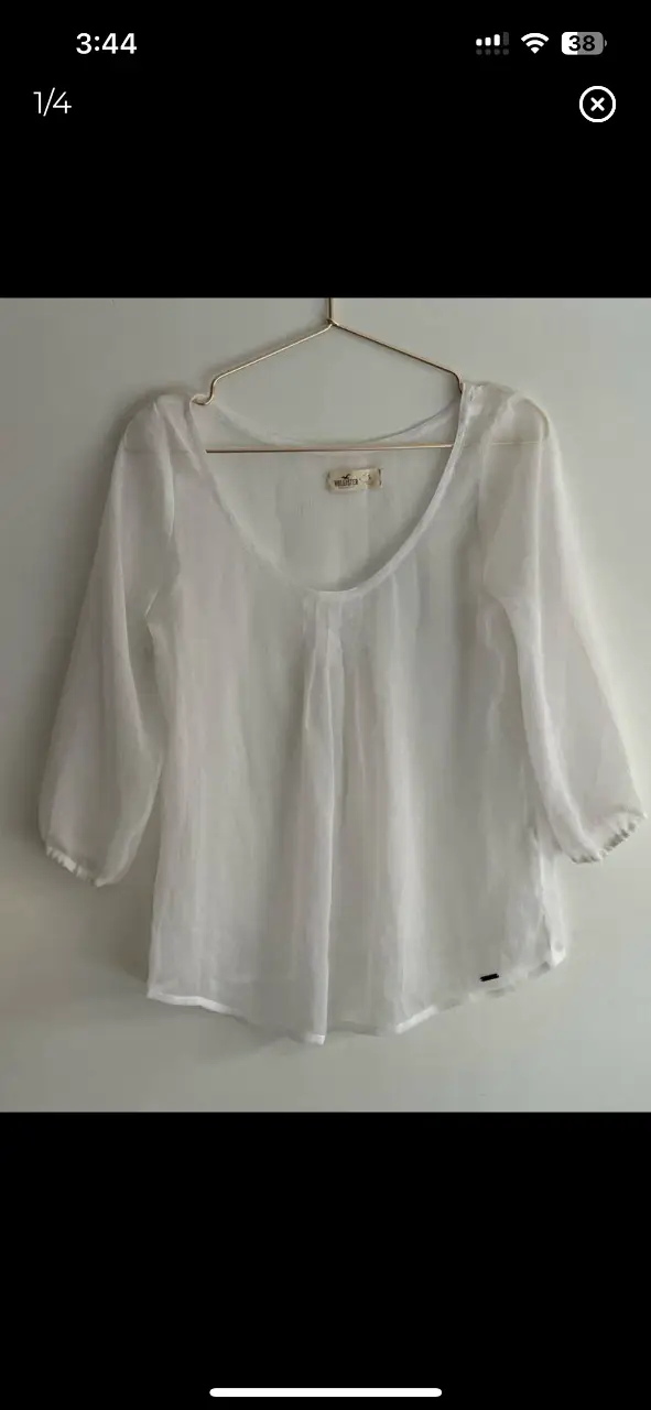 Blusa blanca de gasa Hollister, con mangas 3/4 y cuello redondo. Ideal para un look casual y fresco.