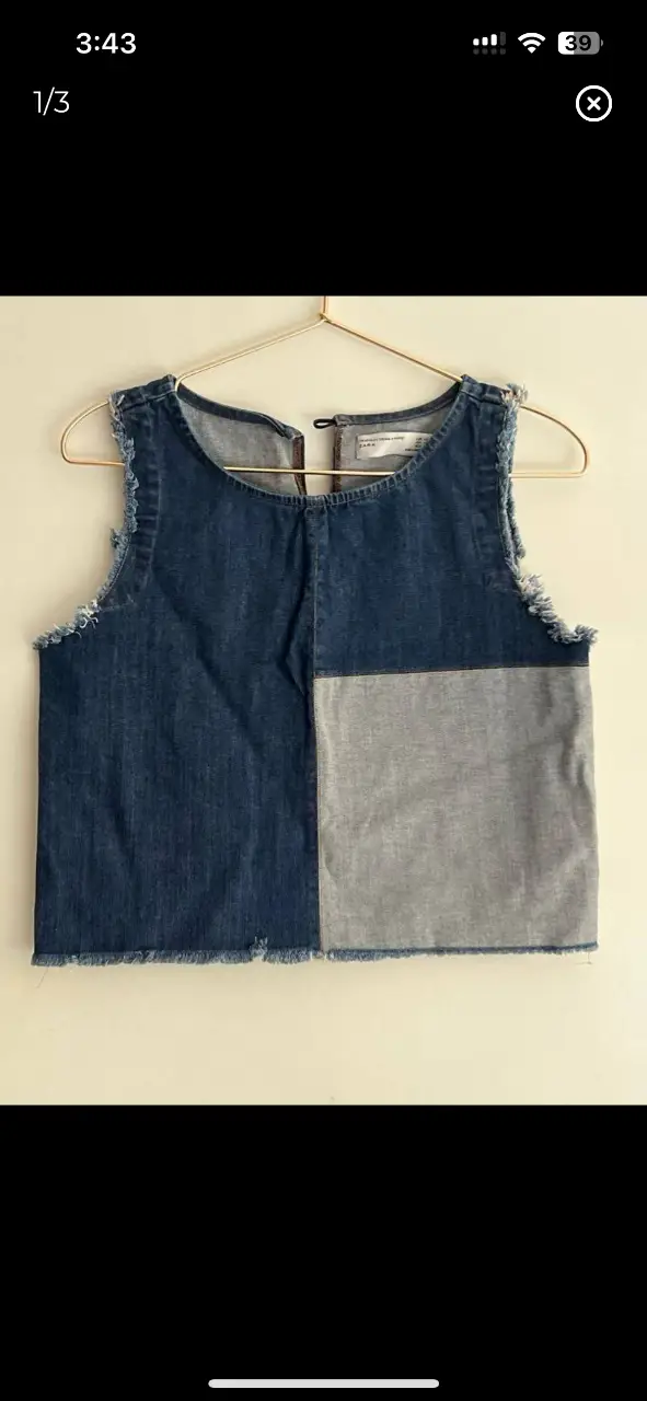 Top de jean con diseño bicolor. Corte recto con detalles desflecados en los bordes. Ideal para un look casual y moderno.