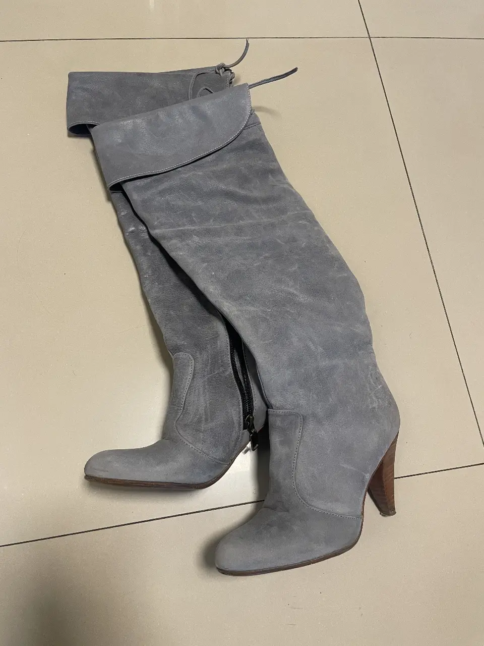 Botas altas de gamuza gris, con taco de madera y cierre lateral. Ideales para un look elegante y sofisticado.