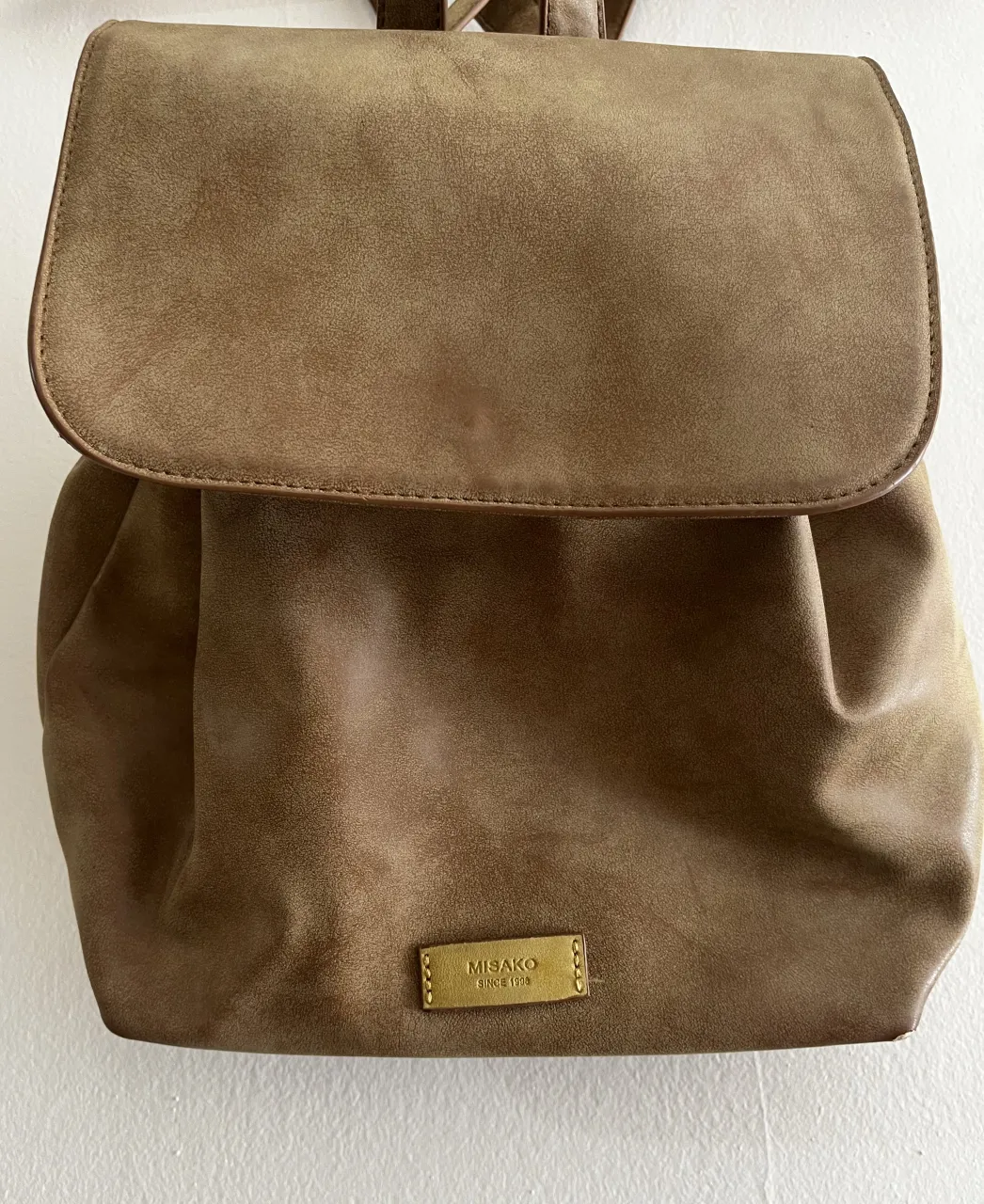 Mochila de cuero sintético color marrón/beige.Marca española MISAKO. Muy espaciosa, con dos bolsillos interiores abiertos y uno con cierre.El bolsillo exterior no se abre. Ideal para un look casual y canchero.