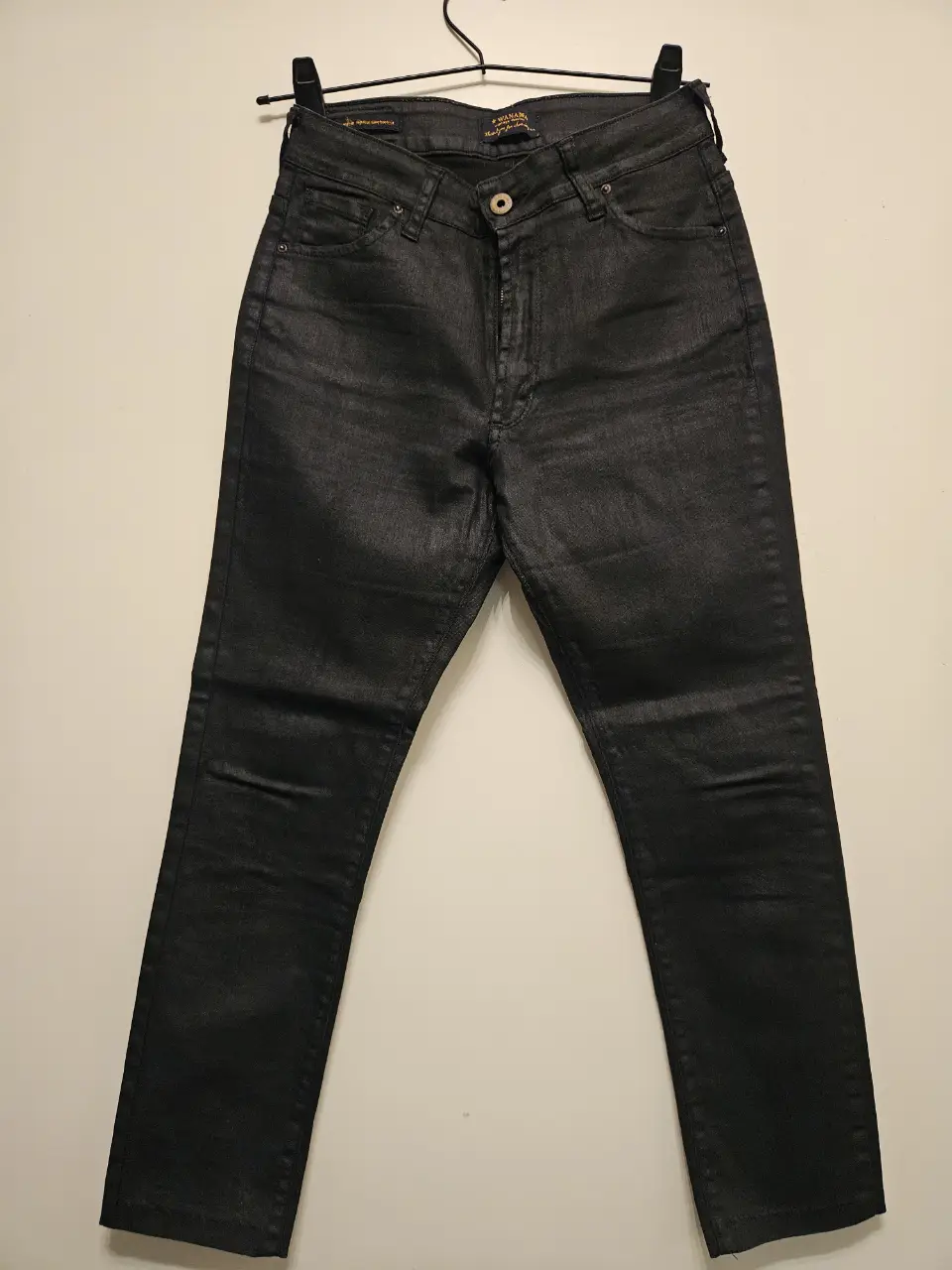 Jeans negro de corte recto, tiro alto, con un acabado brillante. Ideal para un look moderno y versátil.